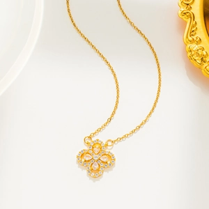 Macro shot of gold clover pendant with zircon crystals on a delicate link chain