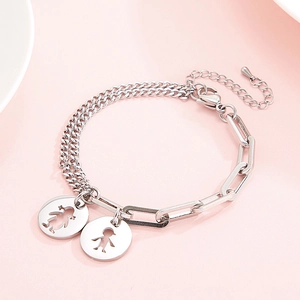Detail view of silver hollow charms with boy and girl silhouettes on a link chain bracelet
