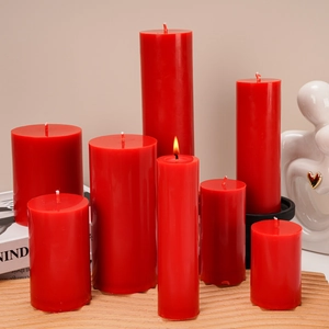 Set of red cylindrical aromatherapy candles in various sizes with warm ambient lighting