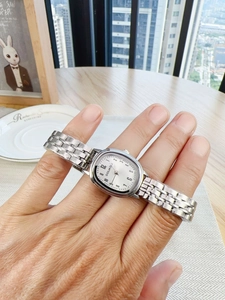 Close-up of a silver vintage ladies quartz watch with a small oval dial and steel strap