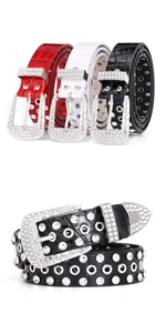 Detail of rhinestone buckle and metal eyelets on crocodile pattern faux leather belts
