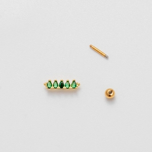 Macro view of golden crown cartilage earring with green teardrop-shaped zircons and screw ball back