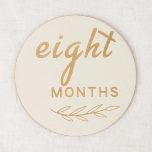 Lot de cartes étapes bébé en bois rond avec gravure huit mois sur un tissu blanc