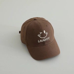 Detail of white embroidered winking smiley face and Laughty text on brown canvas cap