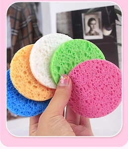Close-up of five colorful round cellulose facial sponges with porous texture for cleaning