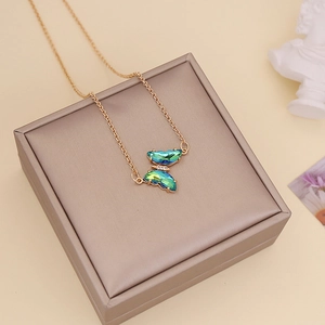 Elegant gold chain necklace featuring a blue-green crystal butterfly pendant on a gift box