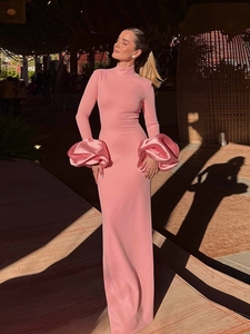 Détail des poignets bouffants sur une robe longue rose ajustée à col montant élégante