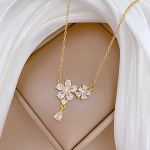 Macro detail of gold flower necklace with zircon stones in a luxury gift box
