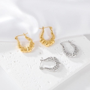 Detail shot of croissant-style textured hoop earrings in gold and silver finish