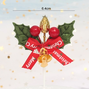 Detail of Christmas cake topper with holly leaves, red berries and gold pinecone