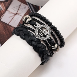 Men's black woven leather bracelet set with compass charm and wooden beads on stand