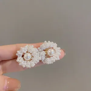 Vue macro de boucles d'oreilles fleur en perles avec base dorée en gros plan