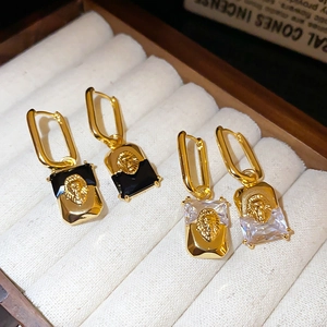 Detail of vintage gold plated lion head earrings with black and white crystals