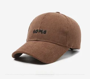 Detail view of brown corduroy baseball cap featuring black embroidered some lettering