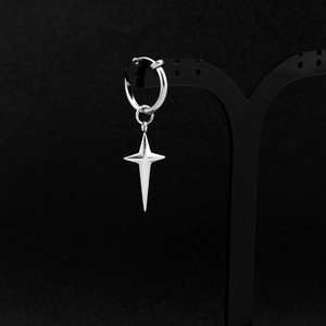 Macro detail of a silver stainless steel hoop earring with a 3D four-pointed star charm