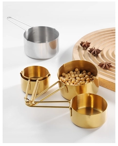 Rose gold stainless steel measuring cups set on wood tray with star anise detail