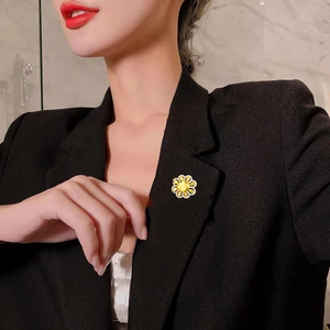 Close-up of a elegant yellow flower brooch with crystals on a professional suit