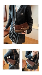 Detail view of brown patchwork suede crossbody bag with gold oval metal lock closure