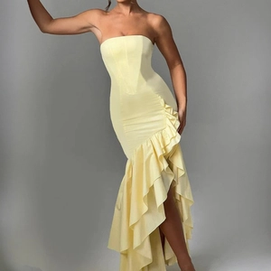 Detail of light yellow corset dress with asymmetrical ruffled hem and satin finish