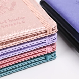 Primer plano de funda de pasaporte oro rosa con grabado de EE. UU. y banda elástica