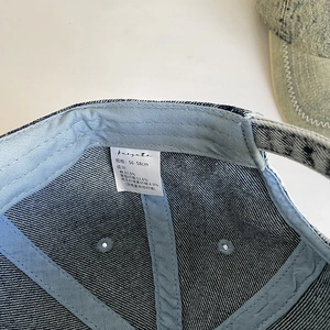 Detailansicht der Innennaht und des Pflegeetiketts der Denim-Baseballkappe aus Baumwolle