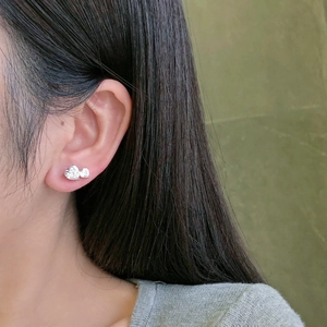 Close-up of S925 sterling silver stud earrings with heart and bow-shaped zircon stones