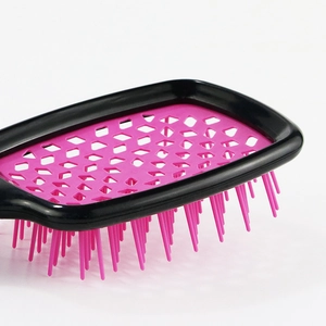 Portable vented hairbrush with pink honeycomb base and black frame for hair styling