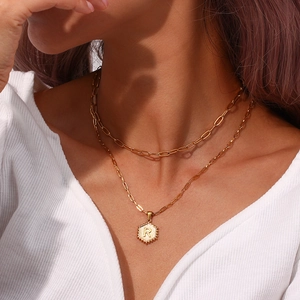 Close-up of double layer paperclip chain with hexagon letter R pendant on a model