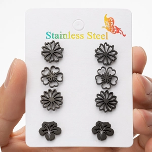 Set of 4 pairs of black stainless steel daisy and flower stud earrings on display card