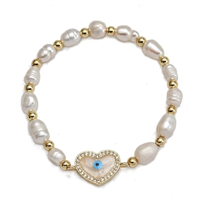 Macro detail of freshwater pearl bracelet with gold evil eye heart charm and white zircons