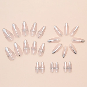 Detail of almond press-on nails with silver 3D cross patterns and sparkling rhinestones