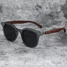 Retro round sunglasses with black frame and brown wood grain temples featuring metal rivets