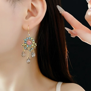 Close-up of bohemian tassel earrings with handcrafted flowers and teardrop crystal beads