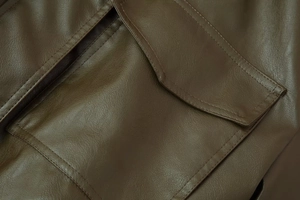 Macro detail of dark brown faux leather jacket showing fine stitching and premium texture