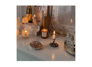 Detail of vintage tulip jewelry set with amber candle and gold lifestyle decor