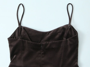 Détail de mini robe en velours marron foncé avec bretelles réglables et zip invisible