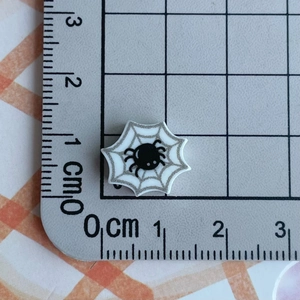 Mini resin spider web charm with 1.5 cm diameter shown on measurement grid