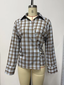 Détail d'une chemise en popeline à carreaux avec col croisé et fermeture latérale