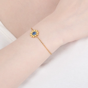 Détail d'un bracelet tournesol en or avec opale bleue porté au poignet d'une femme