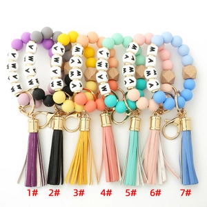 Detailed view of MAMA silicone bead keychains with wood accents in seven colors