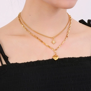 Gold double-layered necklace featuring starburst and heart charms on a sleek chain