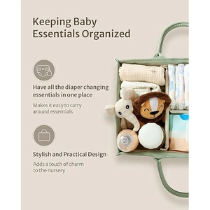 Sage green folding baby diaper caddy with dividers and essentials on beige background