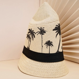 Détail d'un chapeau de paille tissé avec broderie de palmiers noirs et ruban décoratif