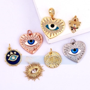 Detailed close-up of gold-plated Evil Eye pendants with colorful enamel and zircons