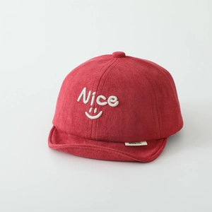 Close-up of red suede baby baseball cap featuring white Nice embroidery and soft short brim