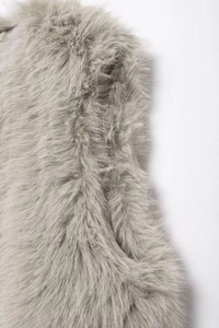 Close-up of light grey faux fur texture showing soft fluffy fibers on sleeveless vest