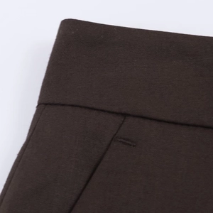 Détail rapproché du pantalon marron foncé avec poches latérales et coutures précises