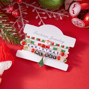 Detailed view of three Christmas bracelets with Santa Claus and tree charms in holiday scene