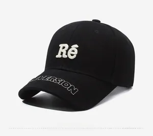 Detail view of black cotton baseball cap with white Ré towel embroidery and curved brim