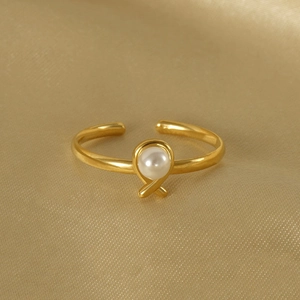 Elegant gold-plated stainless steel open ring with a round white pearl on silk fabric